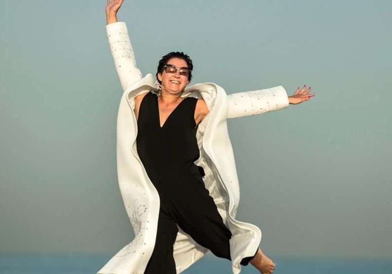 middle-aged-woman-jumping-happily-on-beach