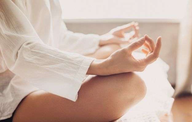 A close up of woman meditating at home | Meditate