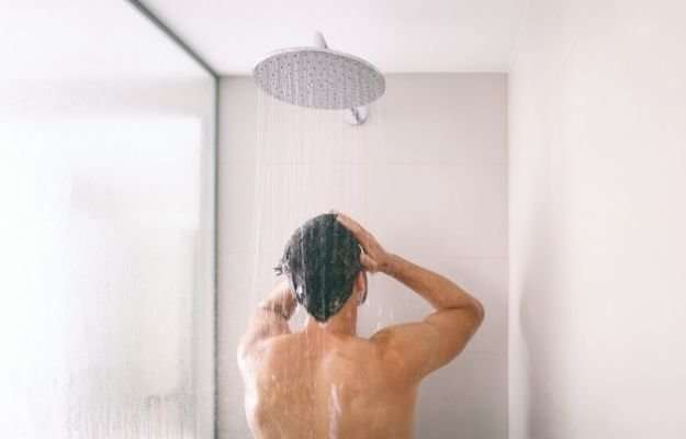 Man taking a shower washing hair with shampoo product under water falling | Use Your Shower Wisely