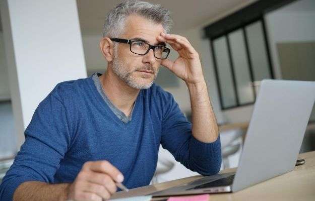 Middle-aged man working on laptop- thoughtful look | Factors That Affect Brain Performance