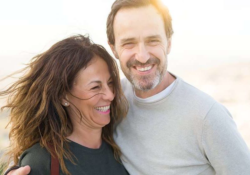 A happy middle aged couple under sunshine near the lake | Feature | What Are the Benefits of BHRT, and Is It Right for You?
