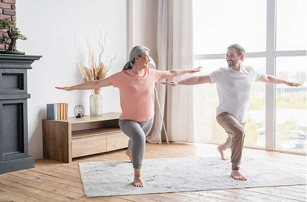 Middle-aged couple training stretching doing yoga exercises together_ Body
