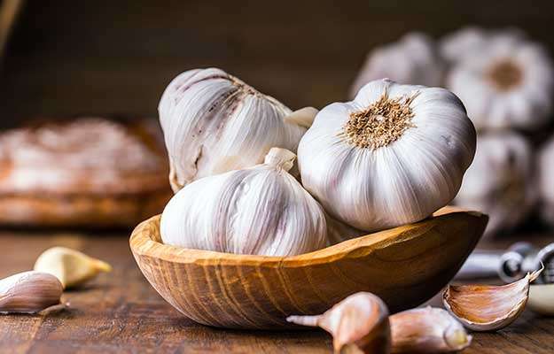 Garlic-Cloves-and-Bulb-in-vintage-wooden-bowl-ss-body | How To Improve Gut Health In # Ways