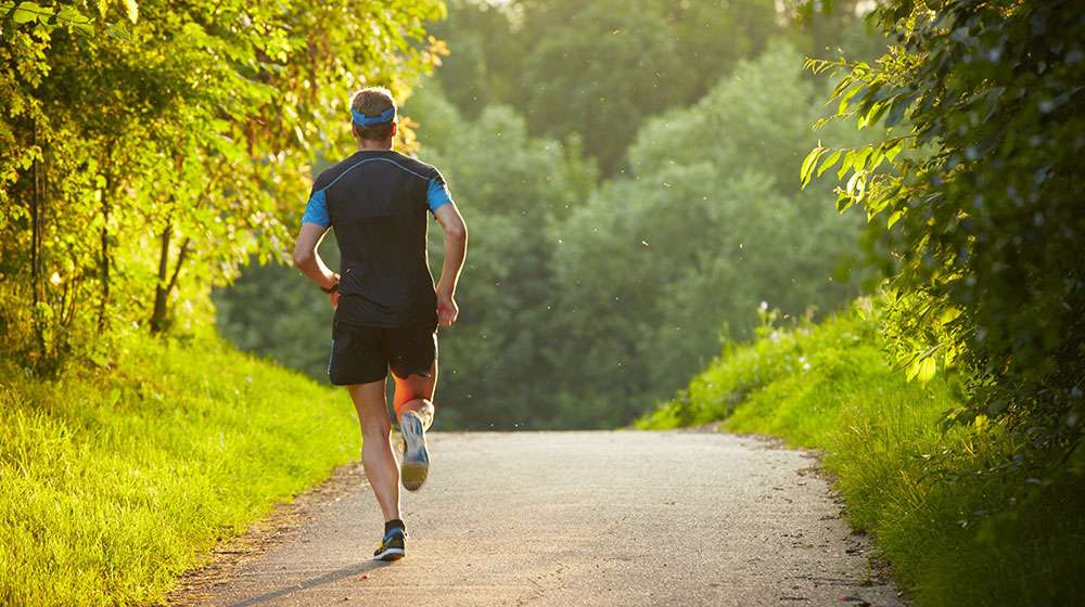 Young-man-is-running-on-road--ss-feat | Scientists Claim That 10,000 Steps A Day Is Not Optimal For Longevity