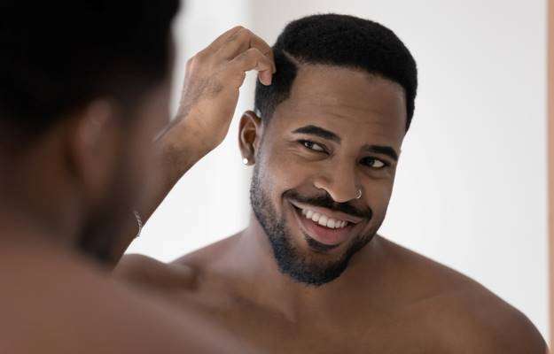 black man touching his hair Preventing Hair Loss