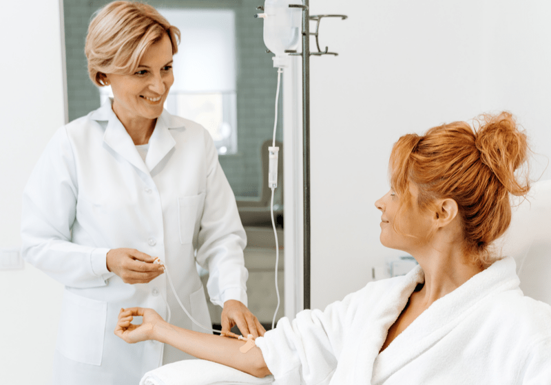 doctor giving woman IV therapy 5 Health Benefits of NAD IV Therapy