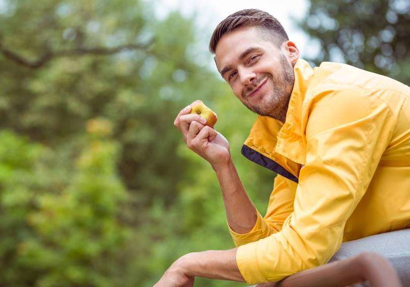 happy guy eating apple 5 Surprising Benefits Of Collagen For Men feat ss