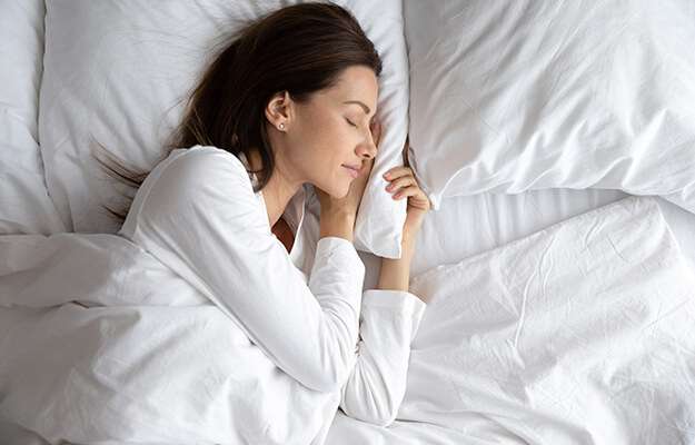 woman sleeping with hand under cheek on soft pillow