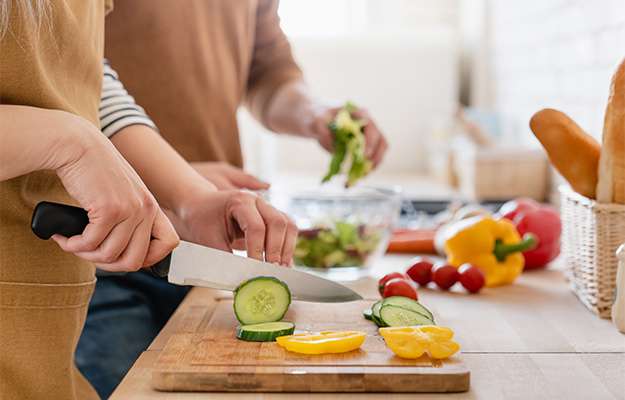 cutting-board-and-couple-cutting-vegetables-in-the-kitchen-How-to-Reduce-the-Risk-of-Heart-Disease-for-Menopausal-Women