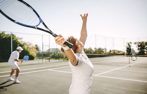 Rear-view-of-a-woman-serving-the-ball-while-playing-a-mixed-doubles-tennis-match.-How-Does-MOTS-c-Peptide-Work