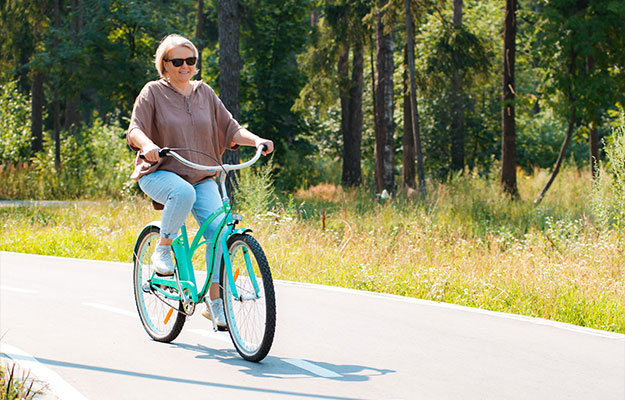 Senior-older-elderly-modern-woman-rides-a-bicycle-in-a-city-park-in-the-forest-How-to-Maintain-Brain-Health-During-Menopause