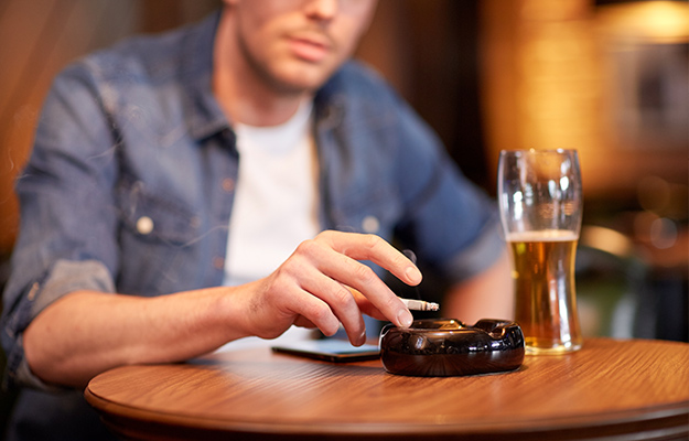 man-drinking-beer-and-smoking-cigarette-at-bar-Smoking-Cessation-Might-Have-a-Restorative-Effect