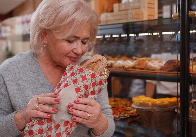 Lovely-senior-lady-buying-fresh-bread-at-local-bakery-store-smelling-tasty-fresh-loaf-of-bread-How-to-Control-Menopause-Hunger