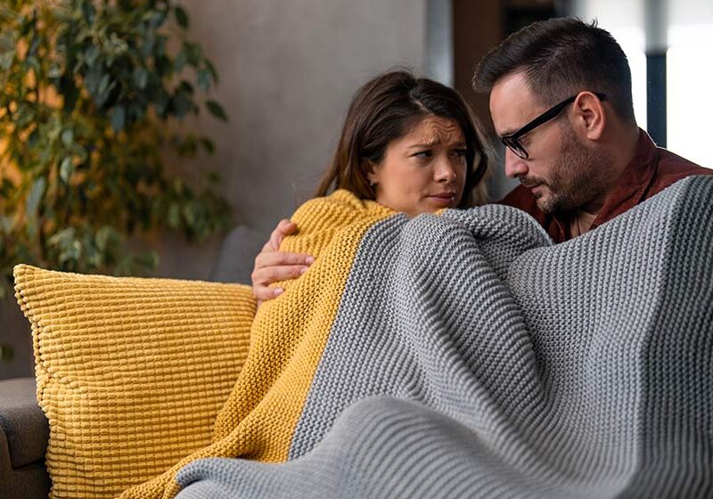 Young-couple-are-sitting-on-a-sofa-at-home-covered-with-a-blanket-freezing-What-Are-Endocrine-Disruptors-Ways-to-Avoid-Them