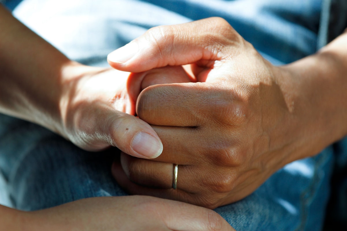 Compassionate hands held together during a warm consultation - Yunique Medical