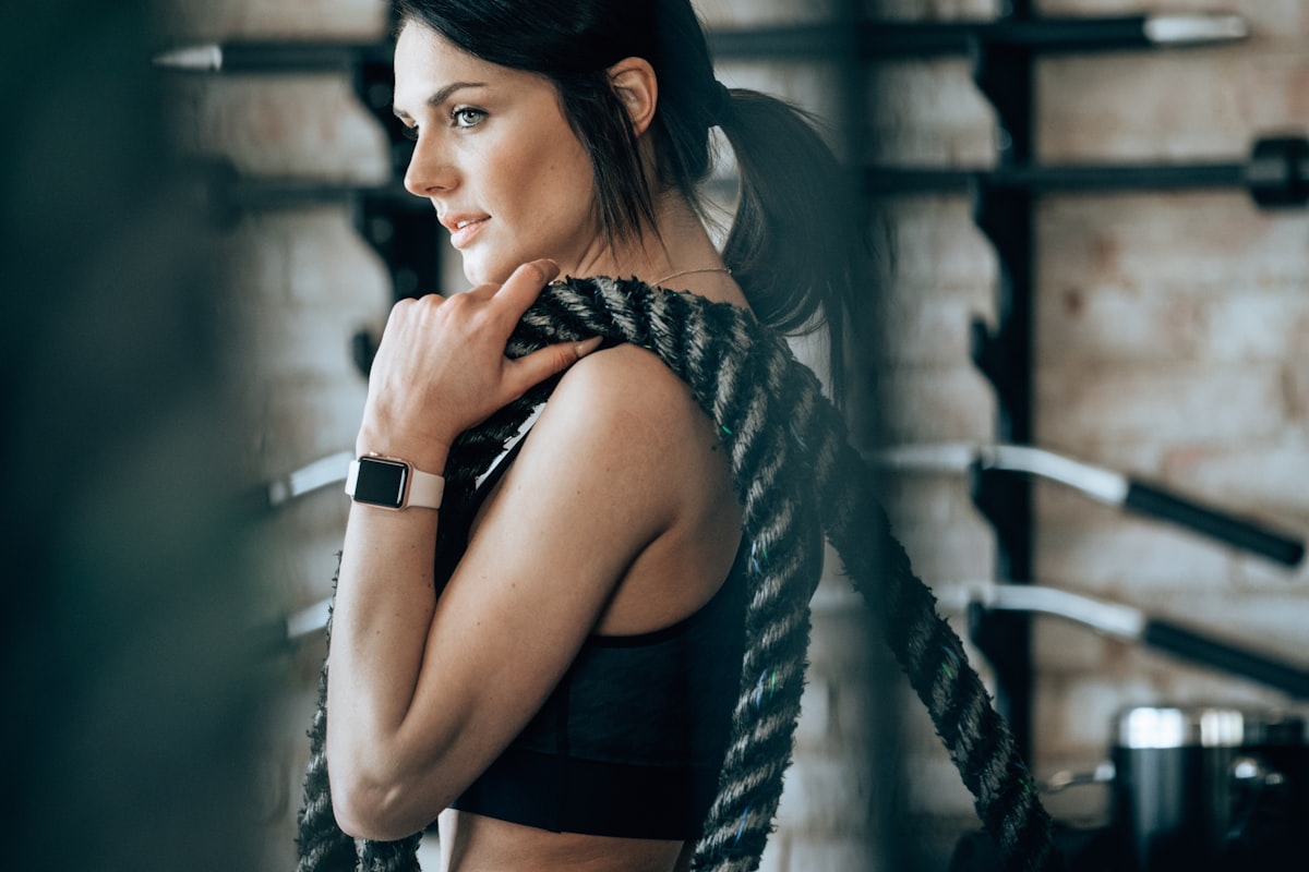 Woman working with battle ropes in a gym - Yunique Medical