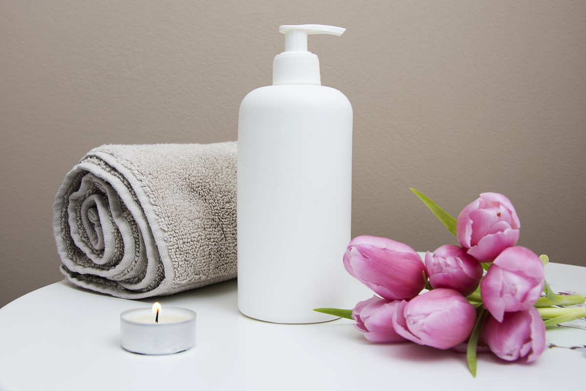 Spa ritual with folded towel, lotion, candlelight and tulips - Yunique Medical