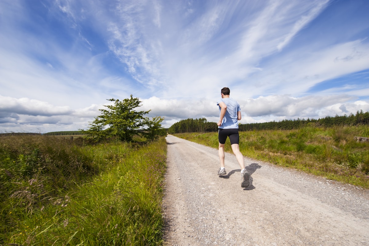 Man jogging on a country road on a clear day - Yunique Medical