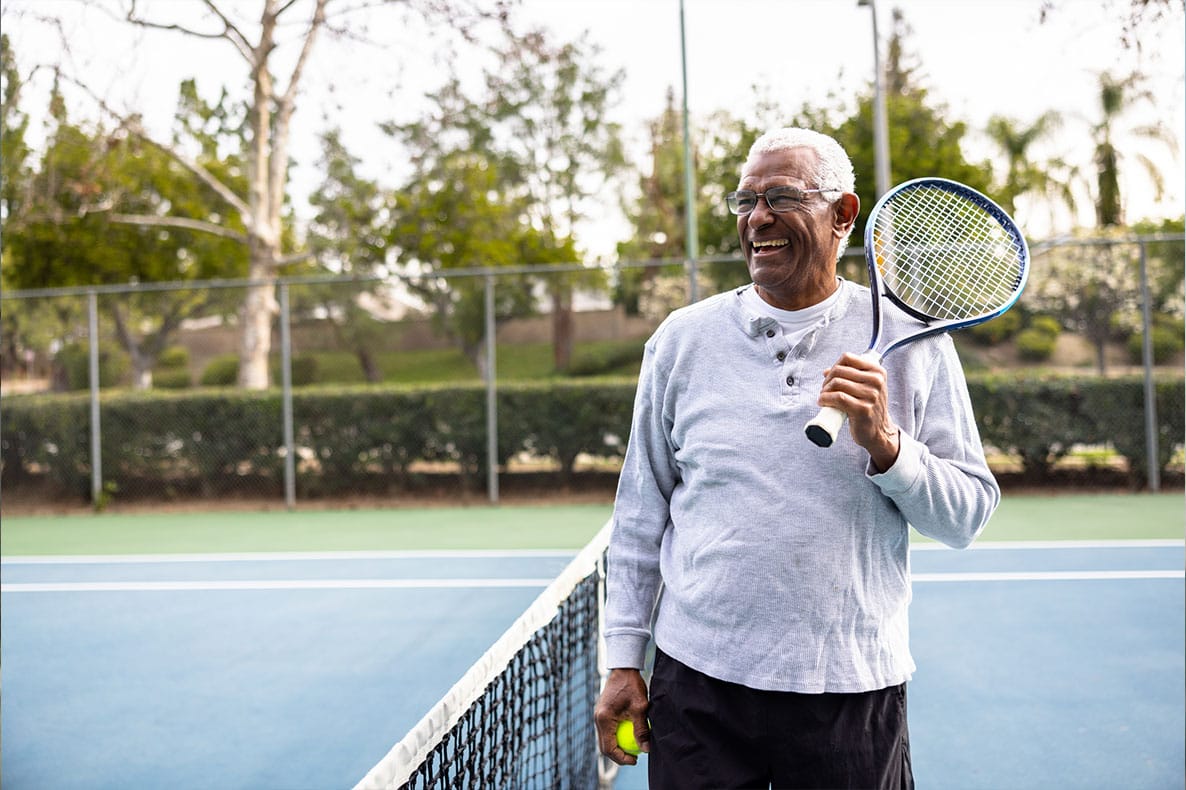 older man playing tennis after starting testosterone pellet therapy