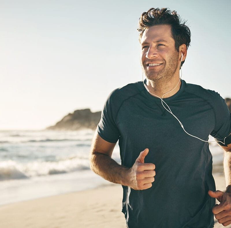 man running on the beach after starting hormone replacement therapy